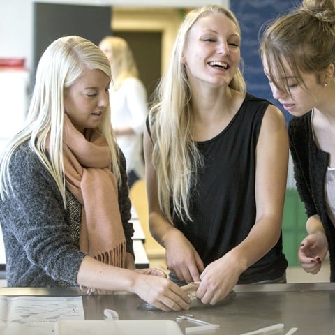 Tre studerende ved et bord